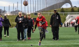 woman kicking a football at the REDBLACKS Woman's Coaching Clinic