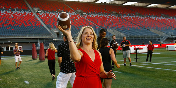 woman throwing a football on the field at TD Place