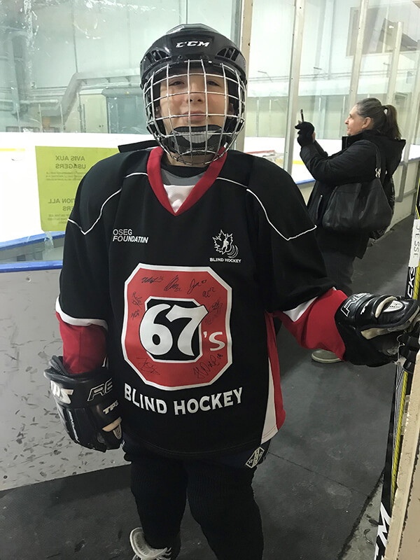 Young boy wearing a Ottawa 67's Blind Hockey Jersey